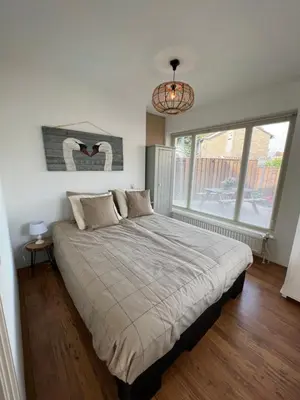 a bedroom with a large bed and a large window at 't Zwanennest Egmond aan Zee in Egmond aan Zee