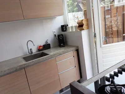a small kitchen with a sink and a window at 't Zwanennest Egmond aan Zee in Egmond aan Zee