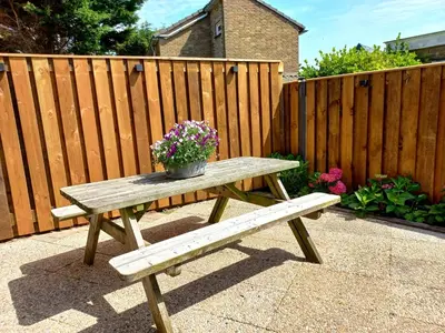 a wooden picnic table with a potted plant on it at 't Zwanennest Egmond aan Zee in Egmond aan Zee