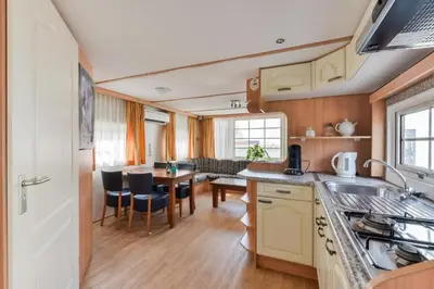 a kitchen and dining room with a dining table at CHALET FOR 2 AT THE BEACH in Zandvoort