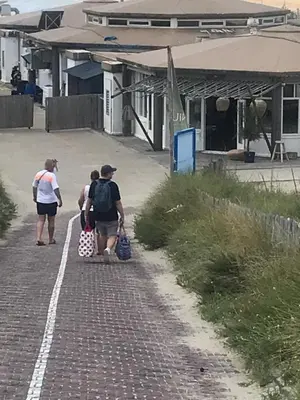 a couple of people walking down a brick road at CHALET FOR 2 AT THE BEACH in Zandvoort
