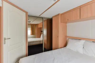 a bedroom with a bed and a mirror at CHALET FOR 2 AT THE BEACH in Zandvoort
