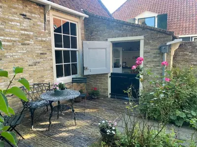 a patio with a table and chairs in front of a building at Characteristic two bedroom home in Edam