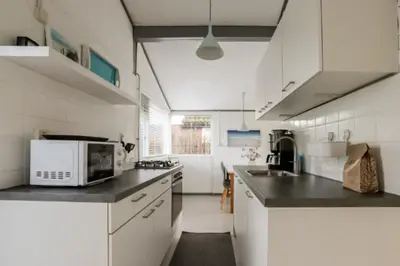 a kitchen with white cabinets and a microwave at Rekerlanden 90 in Schoorldam