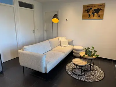 a living room with a couch and a table at Vakantiewoning aan de Kust 16 in Egmond aan Zee