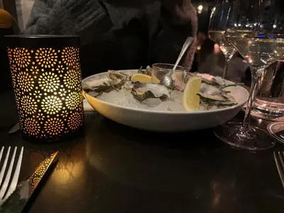 a plate of food on a table with wine glasses at Vakantiewoning aan de Kust 16 in Egmond aan Zee