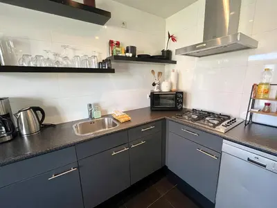 a kitchen with a sink and a microwave at Vakantiewoning aan de Kust 16 in Egmond aan Zee