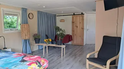 a bedroom with a bed and two tables with plants at Beemster b&b in Zuidoostbeemster