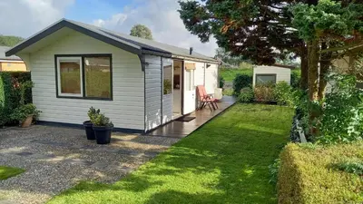 a tiny house in a garden with a patio at Rekerlanden 241 in Schoorldam