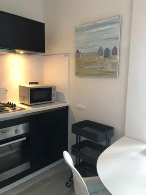 a small kitchen with a table and a microwave at Zee & Zand in Noordwijk