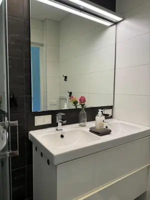a bathroom with a white sink and a mirror at Zee & Zand in Noordwijk
