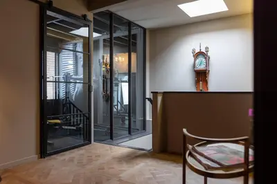 a room with a clock on the wall and a chair at ShortStay Gouda in Gouda
