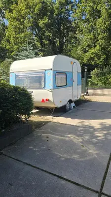 a white and blue trailer parked in a parking lot at Balistyle guesthouse incl Hottub near Amsterdam and Haarlem in Velsen-Zuid