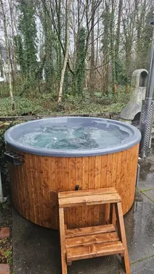 a wooden hot tub with a wooden bench around it at Balistyle guesthouse incl Hottub near Amsterdam and Haarlem in Velsen-Zuid