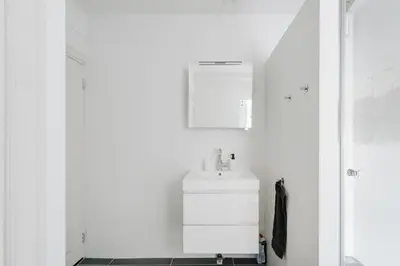 a white bathroom with a sink and a mirror at Luxurious Private Studio Amsterdam Zuid in Amsterdam