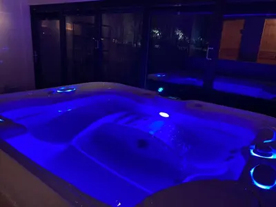 a blue bath tub in a dark room at De Porrel Polsbroek Unit met Privé Jacuzzi, Spa en Sauna in Polsbroek