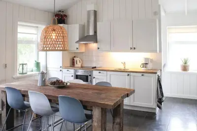 a kitchen with a wooden table and some chairs at Logies De Hooiberg in Lutjewinkel
