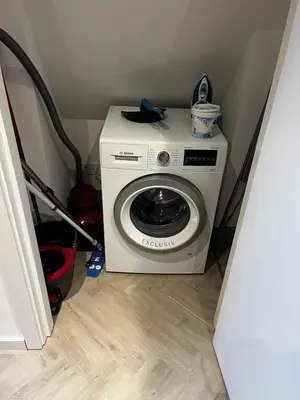 a washer and dryer in a corner of a room at ‘T Singeltje in Leiden