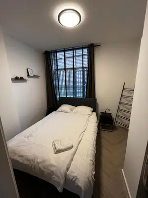a bed in a room with a large window at ‘T Singeltje in Leiden
