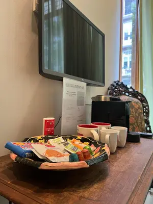 a table with a tray of food and a tv at Boutique Amsterdam Homestay in Amsterdam