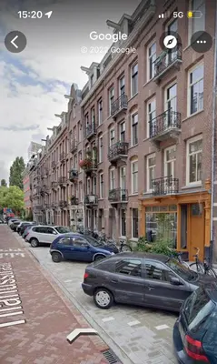 a row of cars parked in front of buildings at Boutique Amsterdam Homestay in Amsterdam