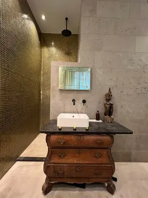 a bathroom with a sink on top of a wooden dresser at Boutique Amsterdam Homestay in Amsterdam