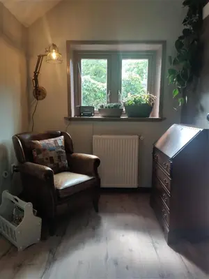 a living room with a chair and a window at Vakantiewoning De Koolboet in Koedijk