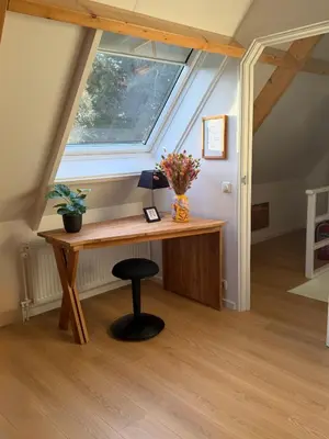 an attic room with a desk and a window at Top appartement in prachtige hart van Nederland Kortenhoef in Kortenhoef