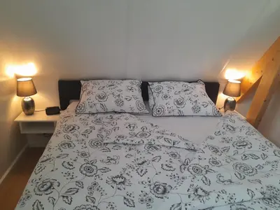 a bedroom with a bed with two pillows and two lamps at Top appartement in prachtige hart van Nederland Kortenhoef in Kortenhoef