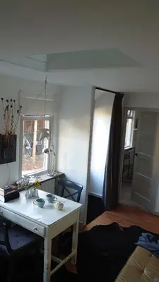a living room with a white table in a room at B en B Sluisje 1818 in Utrecht