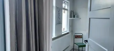 a room with a window and a chair next to a curtain at B en B Sluisje 1818 in Utrecht