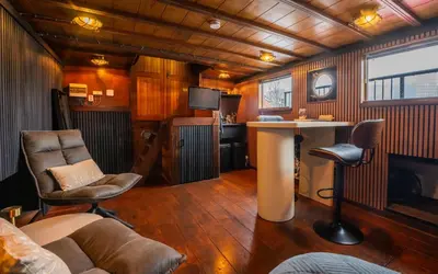 a living room with a table and chairs in a room at Houseboat-Amsterdam-Classic in Amsterdam