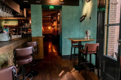 a bar with chairs and a table in a room at Boutique Hotel Brasa Beemster in Middenbeemster