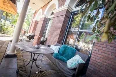 a patio with a table and a table and pillows at Boutique Hotel Brasa Beemster in Middenbeemster