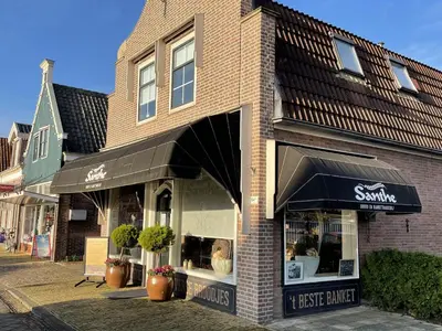 a store front of a brick building with an awning at Boutique Hotel Brasa Beemster in Middenbeemster