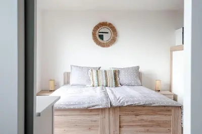 a bedroom with a bed with a mirror on the wall at Windhoek Apartment in Zandvoort