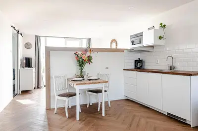 a kitchen with a table with two chairs and a counter at Windhoek Apartment in Zandvoort