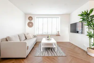 a white living room with a couch and a table at Windhoek Apartment in Zandvoort