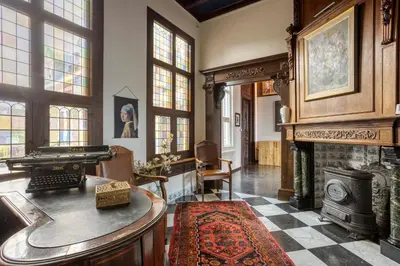 a living room with a fireplace and a piano at Edam Suites in Edam