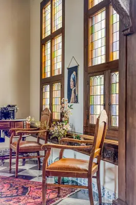 a dining room with a table and chairs and windows at Edam Suites in Edam