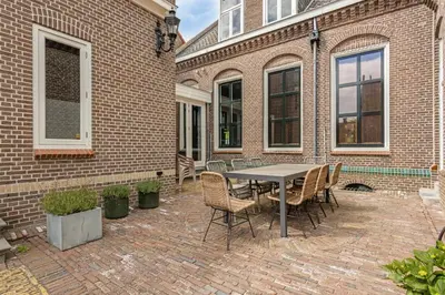 a patio with a table and chairs in front of a brick building at Edam Suites in Edam