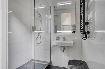 a white bathroom with a sink and a shower at Edam Suites in Edam