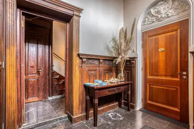 a hallway with a wooden door and a wooden table at Edam Suites in Edam