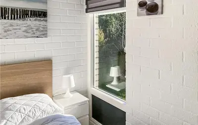 a bedroom with a white brick wall and a window at 3 Bedroom Stunning Home In Dirkshorn in Dirkshorn