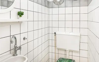 a white tiled bathroom with a toilet and a sink at 3 Bedroom Stunning Home In Dirkshorn in Dirkshorn