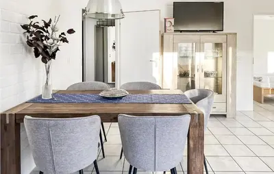 a dining room with a wooden table and chairs at 3 Bedroom Stunning Home In Dirkshorn in Dirkshorn