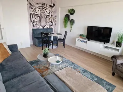 a living room with a couch and a tiger head on the wall at Beach & Sea view in Zandvoort