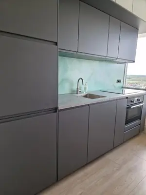 a kitchen with white cabinets and a sink at Beach & Sea view in Zandvoort