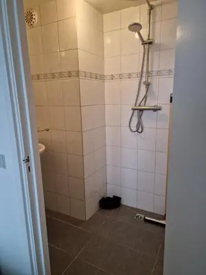 a bathroom with a shower with white tiles at Beach & Sea view in Zandvoort