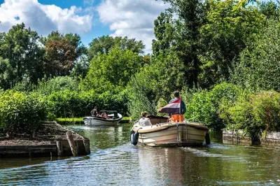 two boats on a river with people on them at Quiet Waterloft near Amsterdam and Schiphol WS17 in Aalsmeer